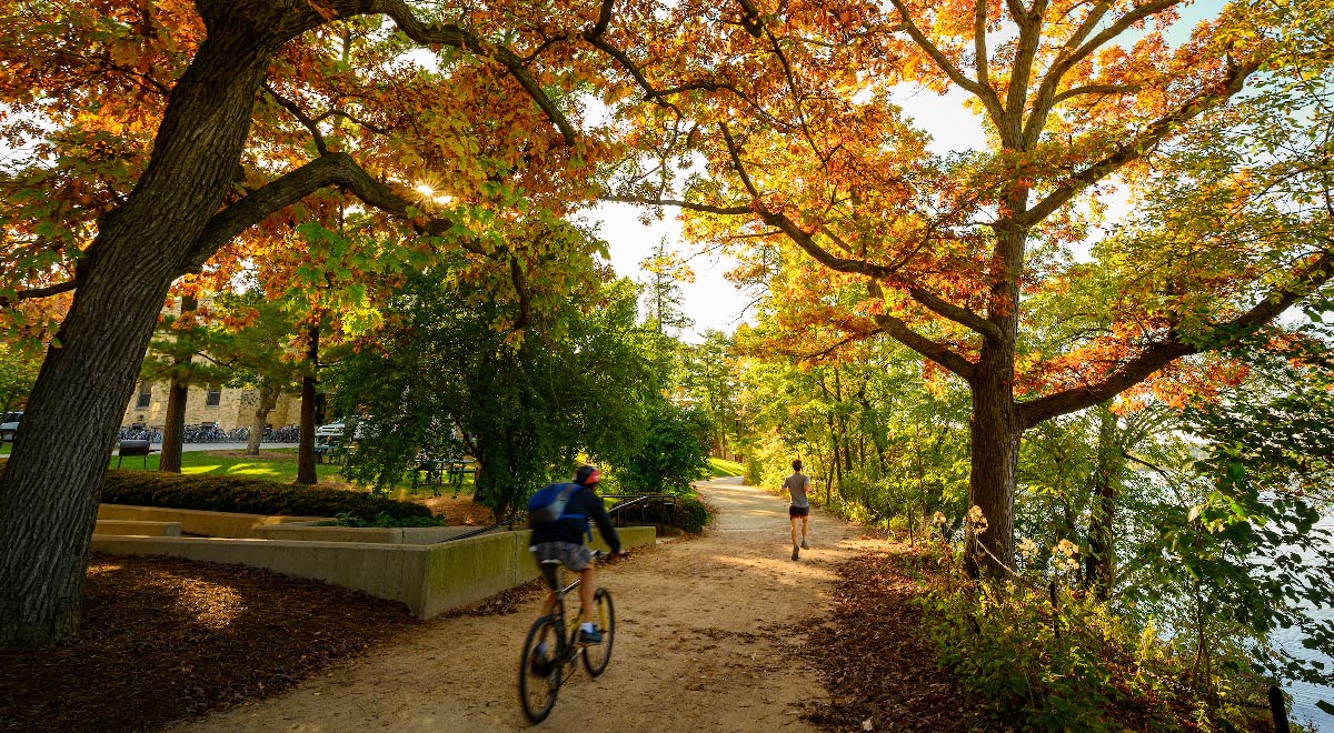 Bicyclist and jogger using Lakeshore Path during autumn