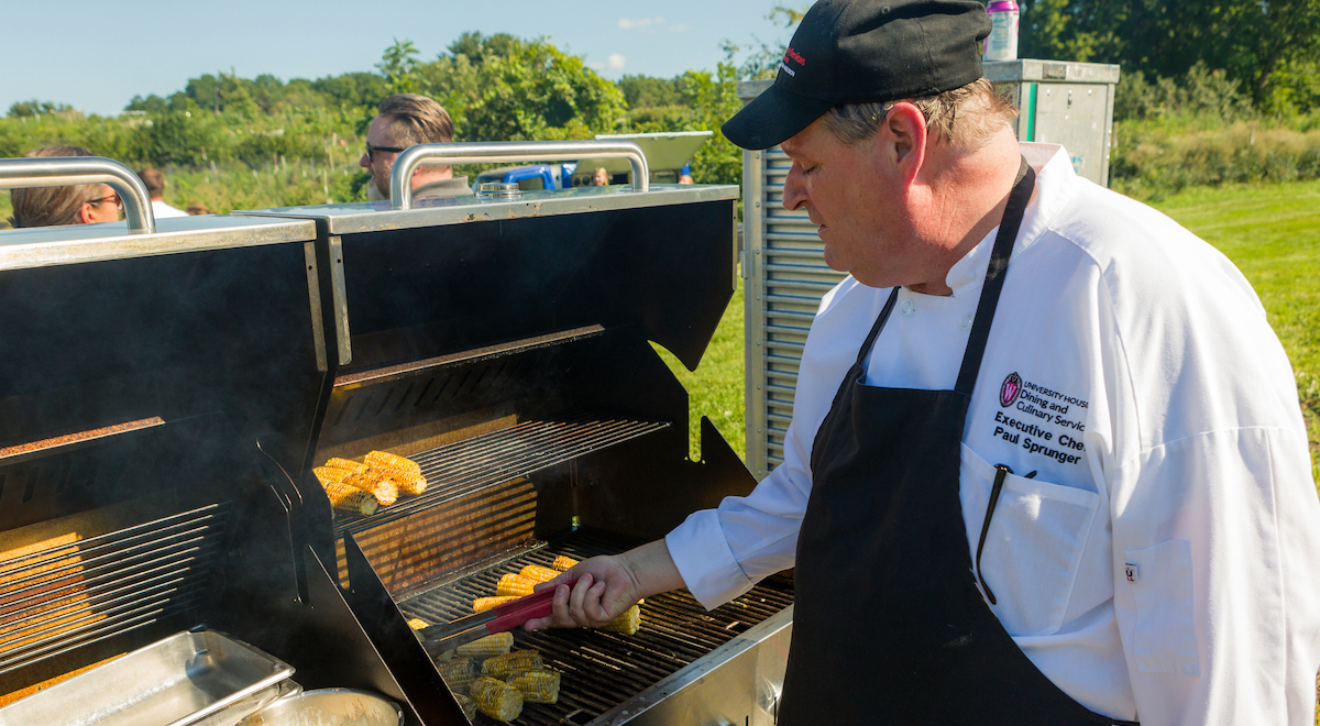 Executive Chef for Dining & Culinary Services, Paul Sprunger, grills corn and other food outdoors