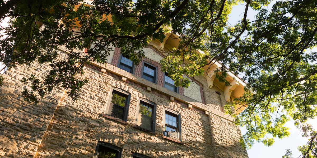 Exterior of Adams Residence Hall near trees in summer