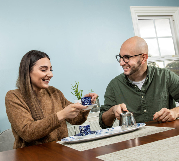Una pareja se sienta en una mesa y bebe café.
