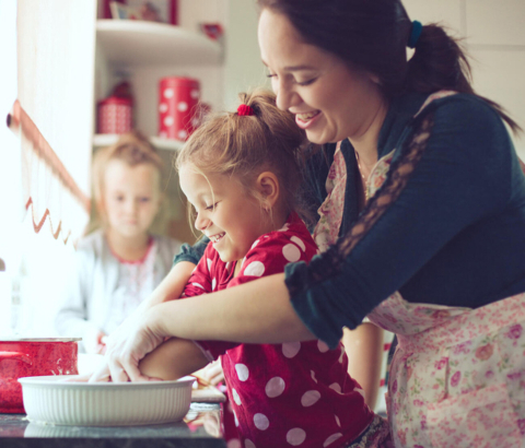 Mother and young daughter baking