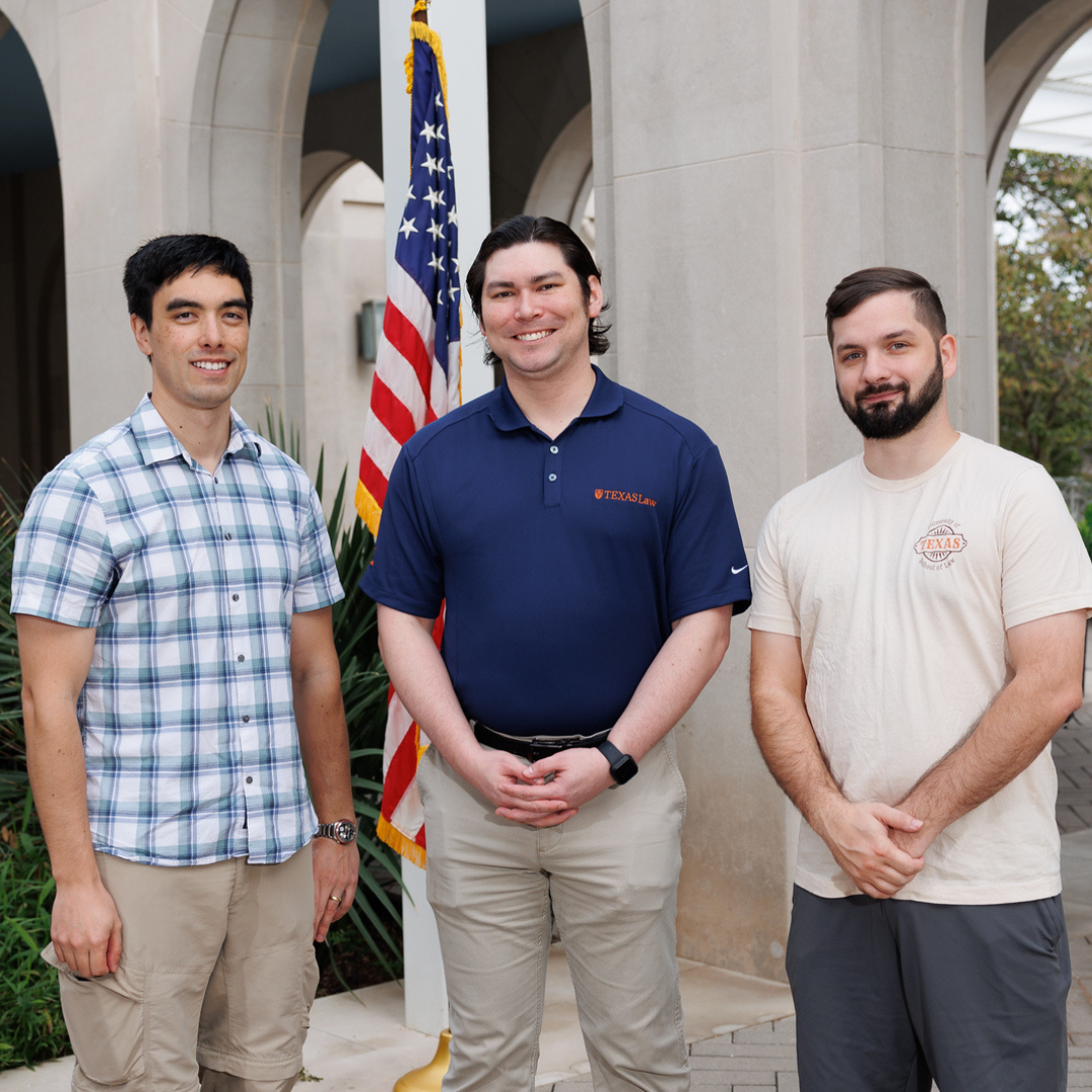 Photo of three veterans who attend Texas Law in front of American flag