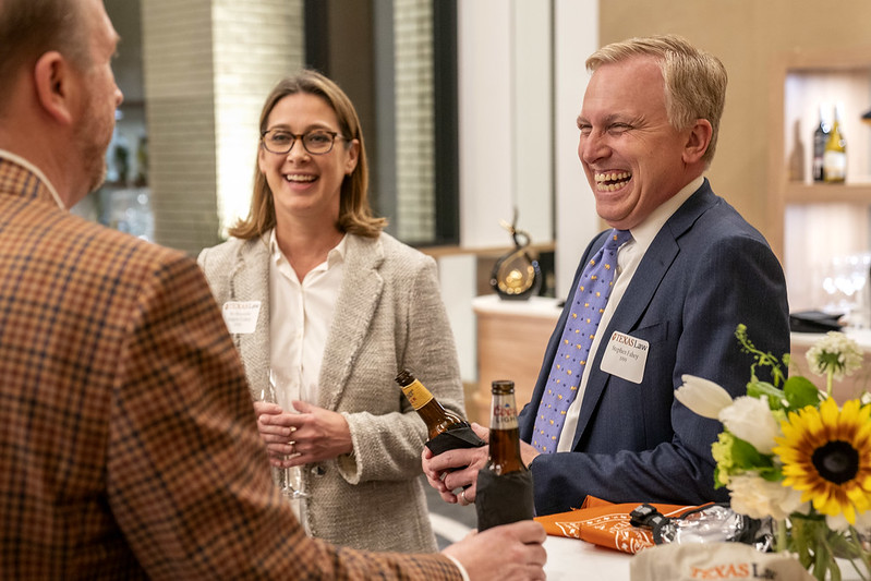 Photo of three Texas Law alumni with one laughing