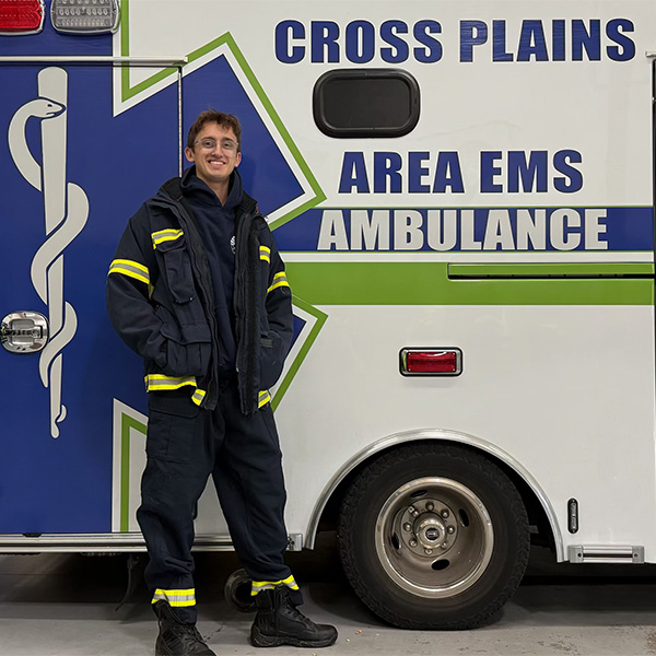 Anthony Lange stands in front of a Cross Plains Ambulance.