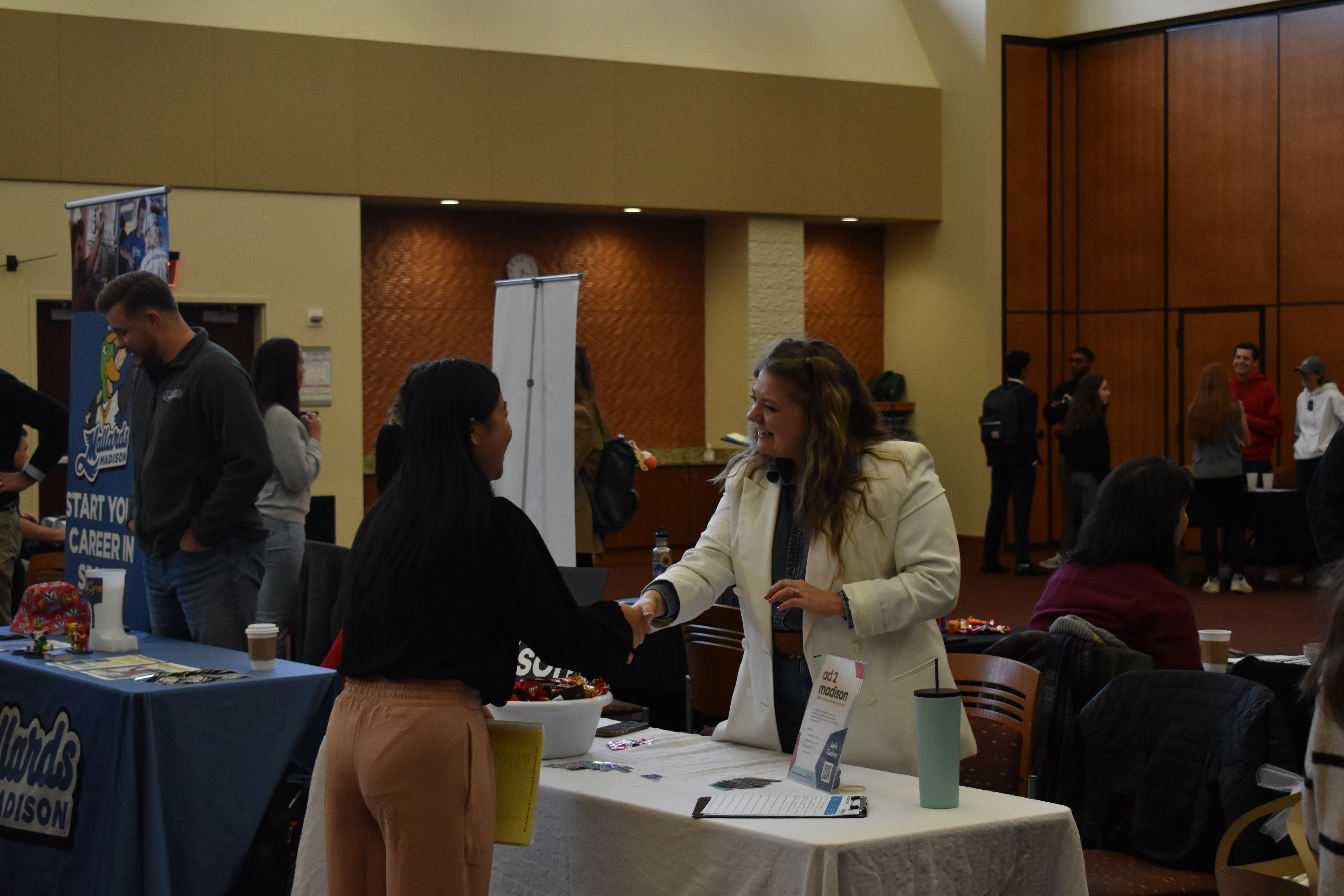 A student shakes hands with an employer at the Advertising and Communications Career Fair