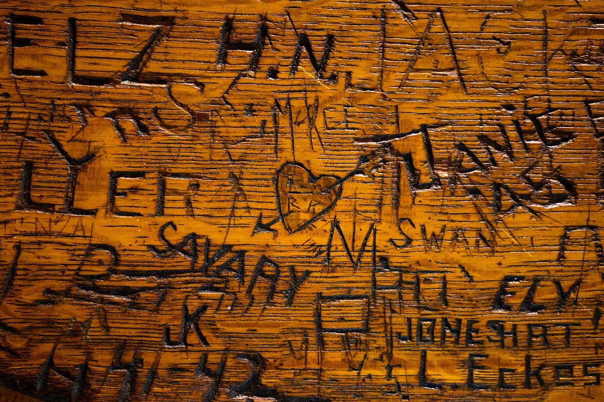 Heart and names carvings in Der Rathskeller wooden table