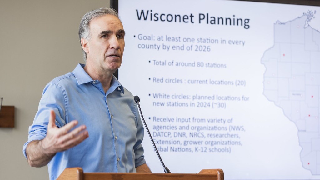Chris Kucharik speaks at a podium in front of a presentation.