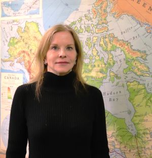 Sarah Moore poses in front of a map
