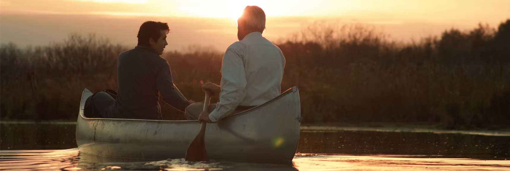 Photo of two people in a canoe paddling through the Waubesa Wetlands at Sunrise - photo used with permission from Ben Albert.