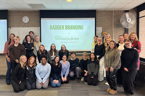 Students pose together the founder of Milwaukee Diaper Mission