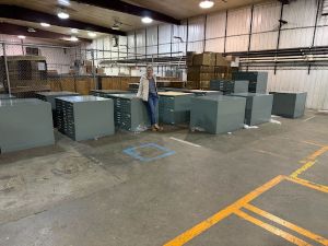 Woman stands in warehouse with map cases