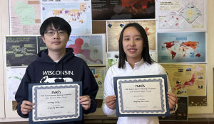 Two students pose with award certificates