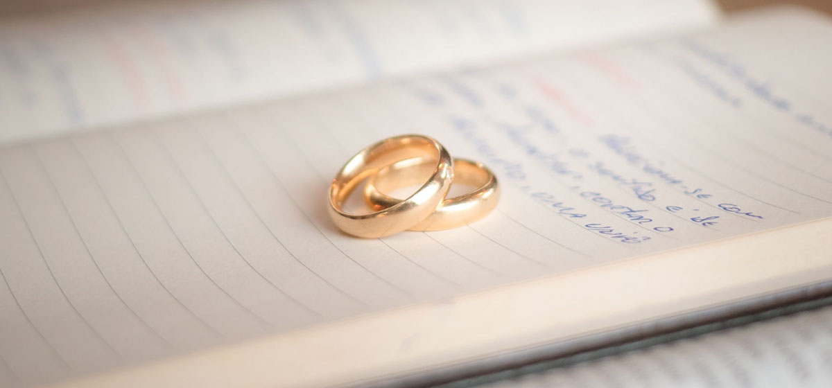 Two wedding bands laying on an open notebook.