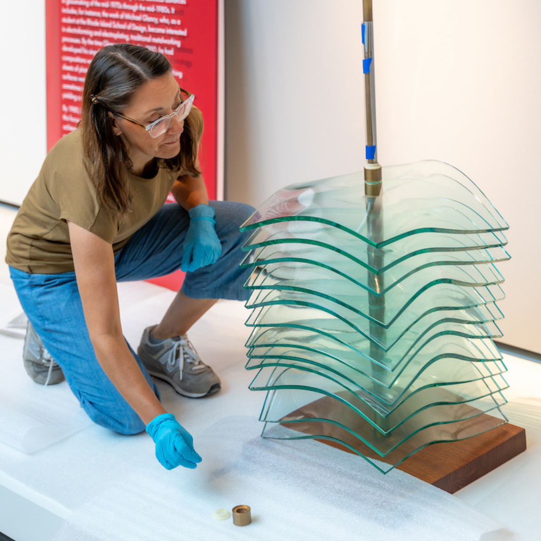 Collections registrar Andrea Selbig installs a glass sculpture at the CHazen.