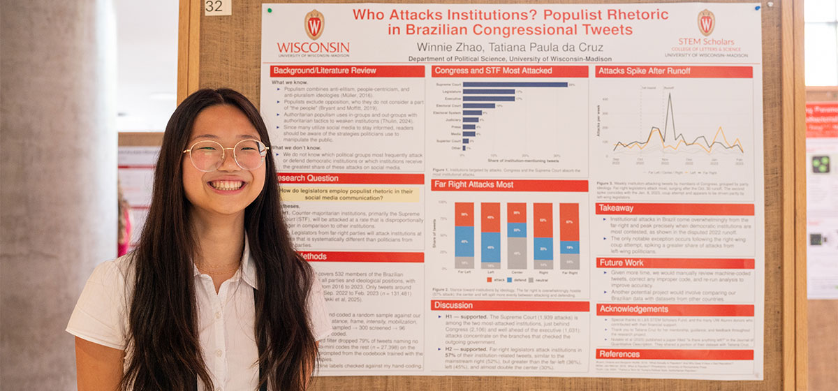 Biochemistry major Winnie Zhao smiles for camera in front of research project poster.