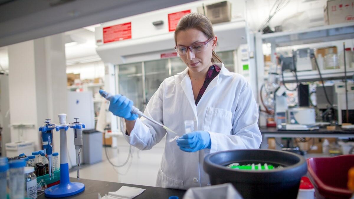 Dr. Smith wears a white lab coat and conducts an experiment in a lab.