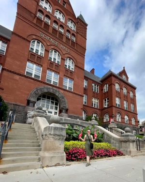 Angelina Stone poses with pink lawn flamingos in front of Science Hall