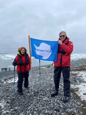 Carl and Sandra Lindstrom pose with a flag in Antarctica