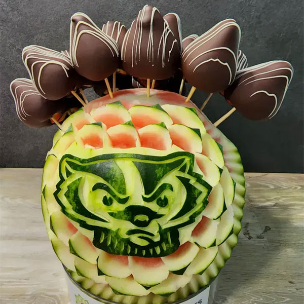 A fruit arrangement carved melon with Bucky Badger logo carved into the center.