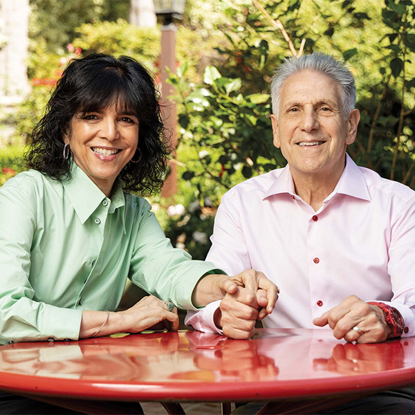 Julie and Peter Weil sitting together outside.