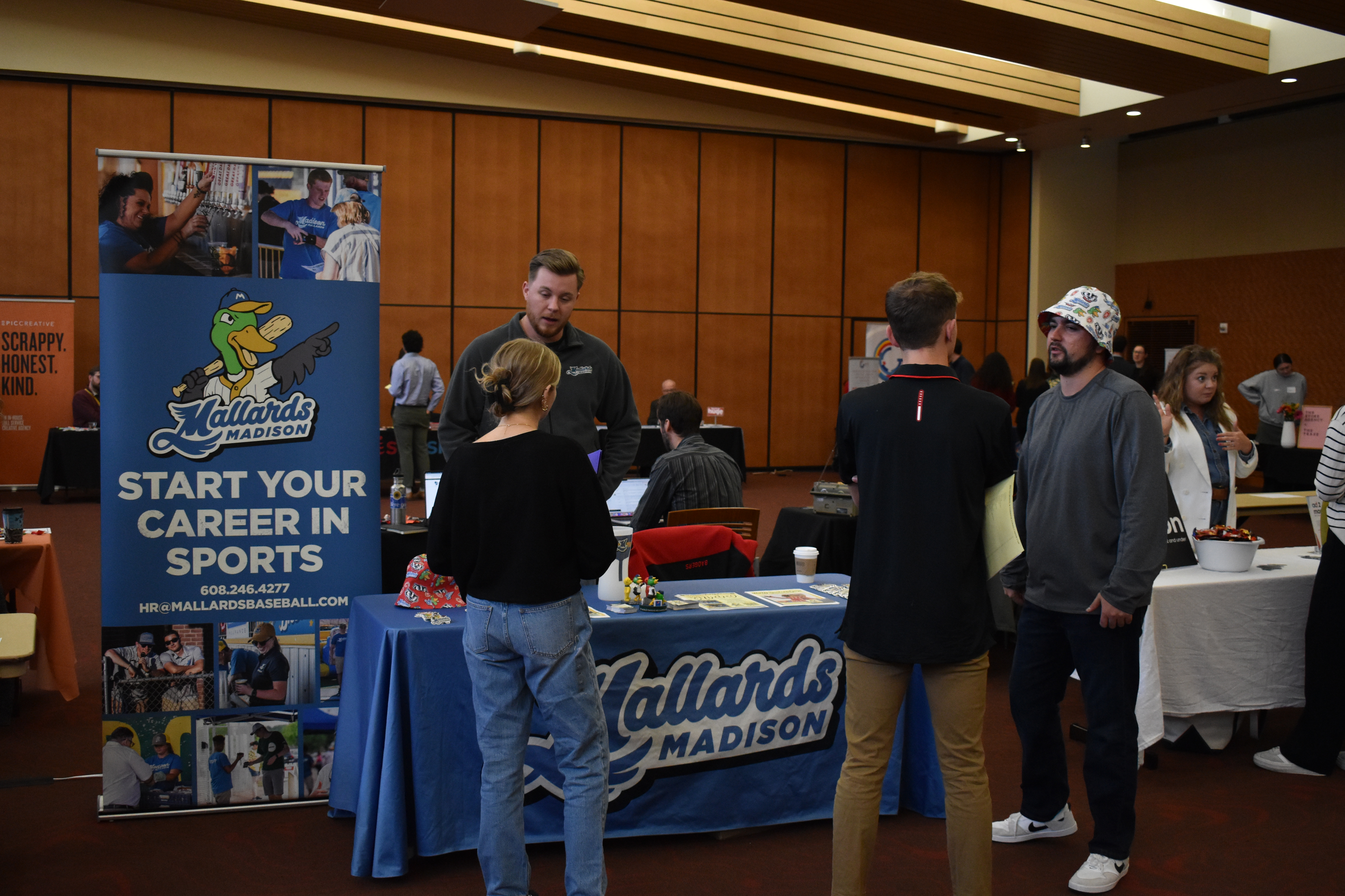 Two students meet with representatives from the Madison Mallards at the Advertising and Communications Career Fair