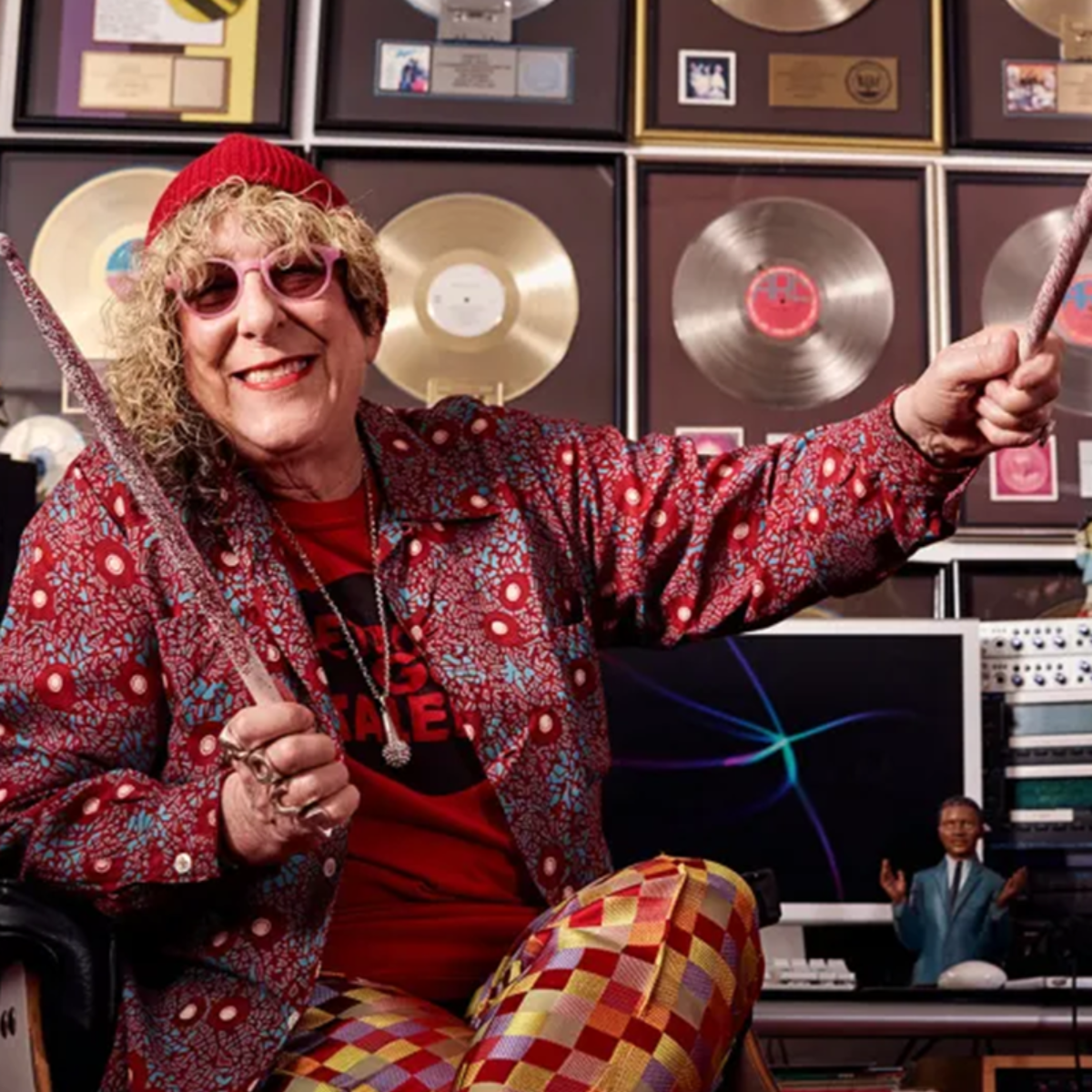 Allee Willis poses with a wall of gold and platinum records. Photo courtesy of the Willis Wonderland Foundation.