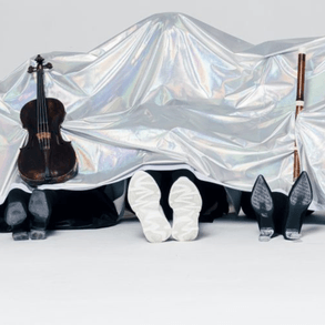 Members of Verità Baroque are pictured under a metallic silver sheet, with only their shoes and instruments visible.