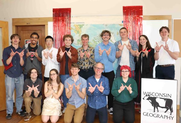 Group of people pose together with their hands in the W shape
