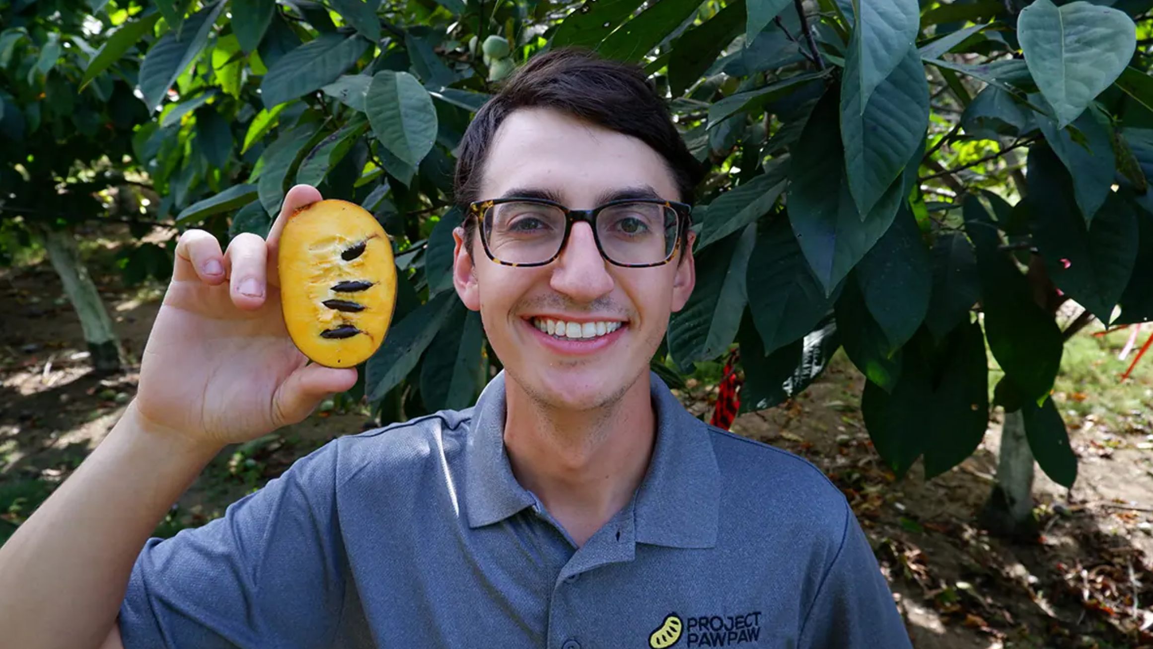 Adam D.Angelo smiles while holding a pawpaw.